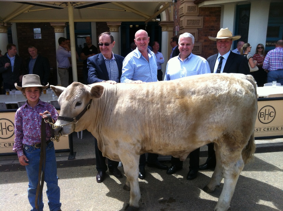 Young handler Billy Goetsch with the record breaking led steer after the auction, with from left, David Beak, B&J, Geoff Atkinson Beak a la Carte, Terry Nolan, Nolan Meats, and auctioneer Darren Perkins.
