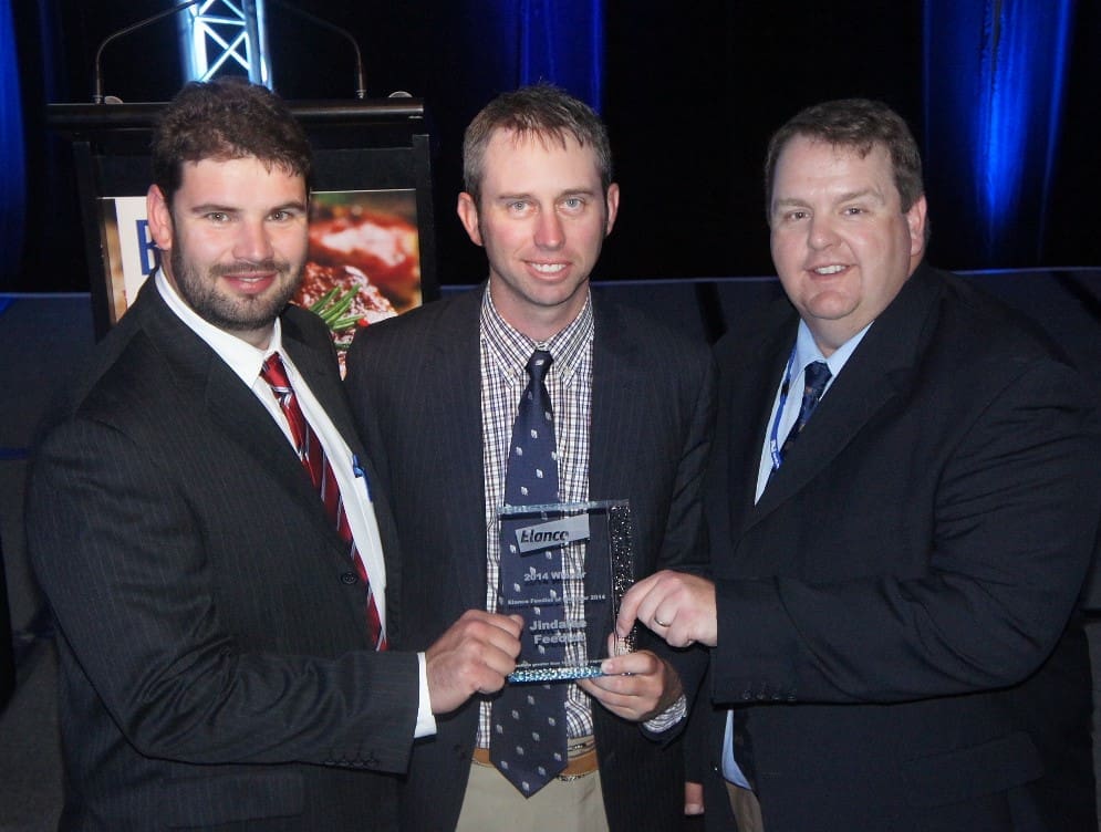 Teys Australia Jindalee manager Shane Bullock and general manager feedlots Grant Garey receive the Feedlot of the Year trophy from Elanco's Nathan Surawski
