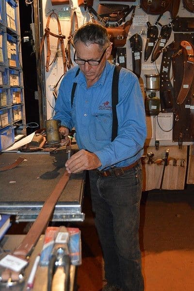 Lyle putting the finishing touches on a belt, with the hole punch