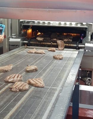 Flame griller used as part of the microwave-ready meals production process